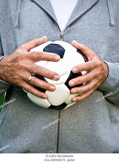 Mans hands holding football
