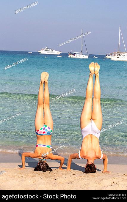 Headstand, sisters, from behind, sea