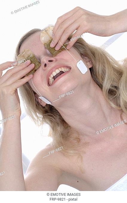 Woman holding teabags in front of her eyes