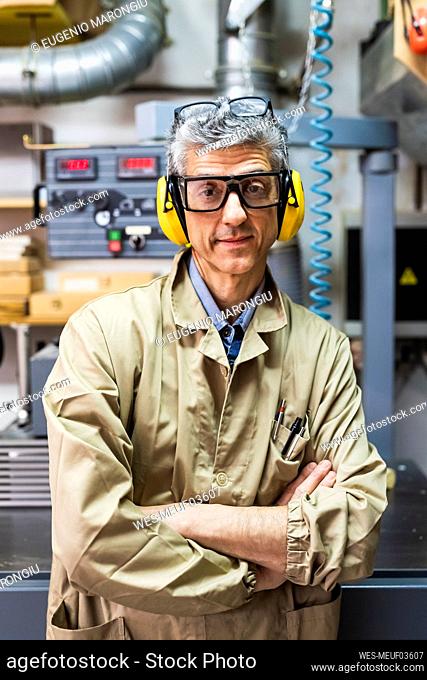 Mature male owner with arms crossed at workshop
