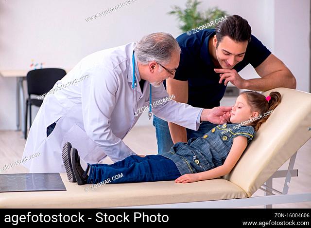 Young father and his daughter visiting old doctor