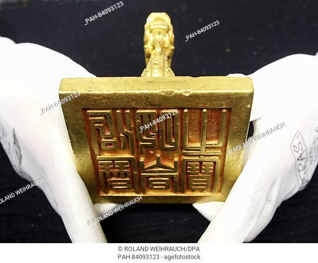 An employee presents the around 4.7kg gold seal from Emperor Minh Mang (1827) in the Archeology Museum in Herne, Germany, 21 September 2016