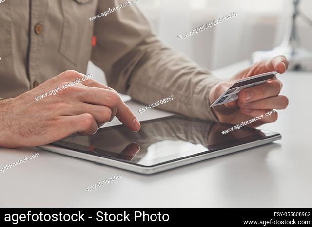 Man holding tablet pc and credit card at the table, shopping online