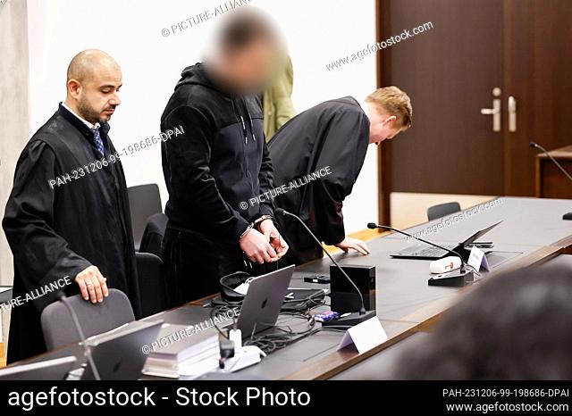 06 December 2023, Bavaria, Nuremberg: The 29-year-old accused of the fatal shooting on a busy Nuremberg street stands in handcuffs between his defense lawyers...