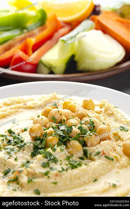Low angle view at vegetable Hummus dip dish topped with chickpeas and olive oil