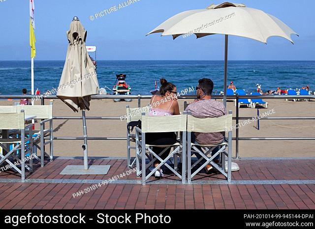 14 October 2020, Spain, Gran Canaria: Customers are sitting outside a bar on Las Canteras beach in Gran Canaria. The Canary Islands have the lowest number of...
