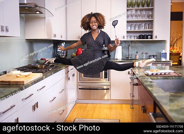 A ballet dancer taking her dancing home with her, cooking breakfast