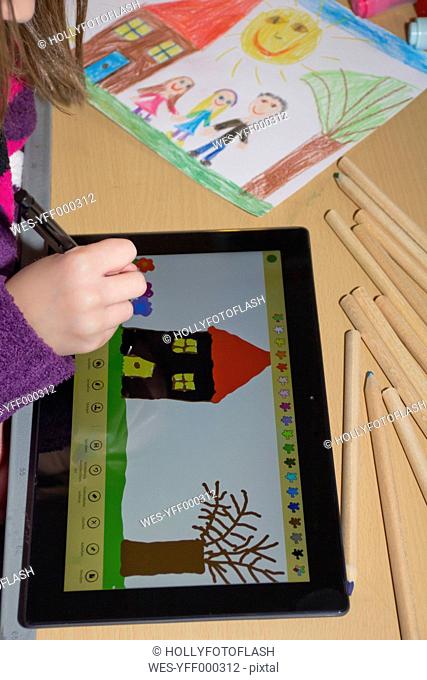 Girl's hand drawing on digital tablet