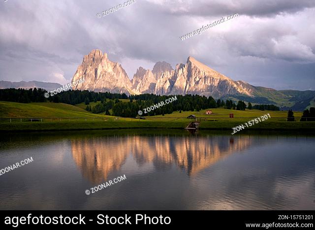 Sassolungo mountains on the Italian Alps Dolomites with water reflection on a lake
