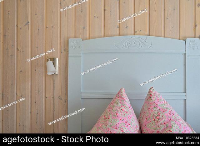 Wooden panels with bed headboard and pillow in holiday home