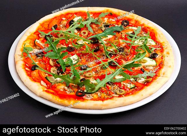 Lean pizza Margherita with cheese, arugula, tomato sauce on a white plate