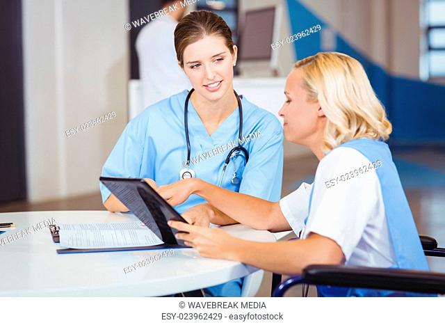Female doctors using digital tablet while discussing