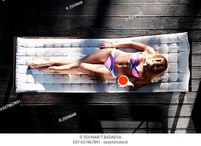 Woman relaxing in chaise lounge