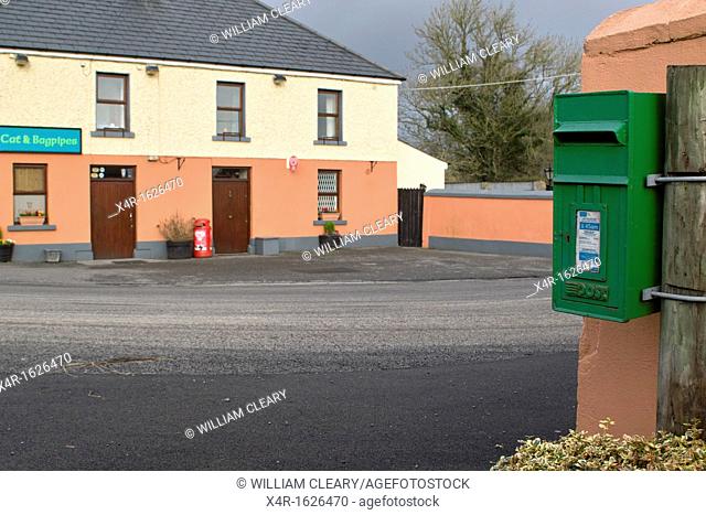 The Cat and Bagpipes Pub in Tubber village, Co. Offaly, Ireland, with postbox in foreground