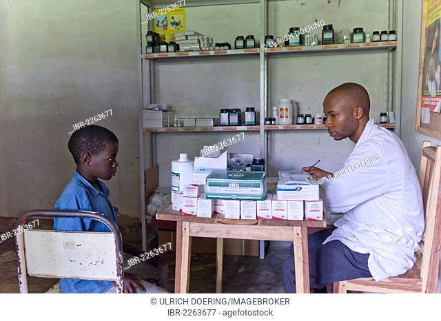 Boy receiving anti-retroviral medicines in an HIV-AIDS clinic from a pharmacist, Quelimane, Mozambique, Africa