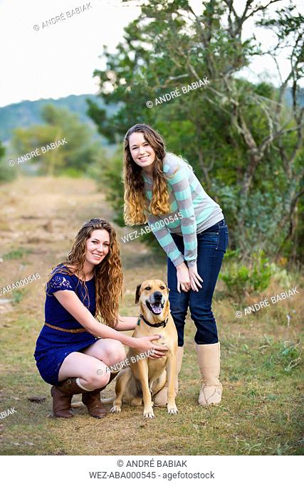 USA, Texas, Sisters with Blackmouth Cur, smiling, portrait