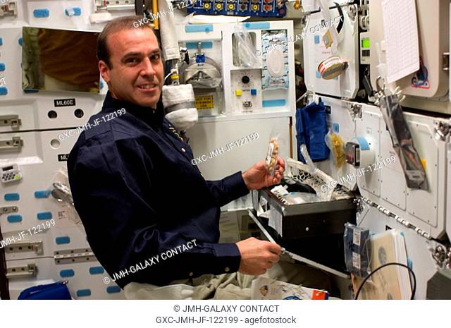 NASA astronaut Rick Mastracchio, STS-131 mission specialist, prepares to eat a snack at the galley on the middeck of space shuttle Discovery while docked with...