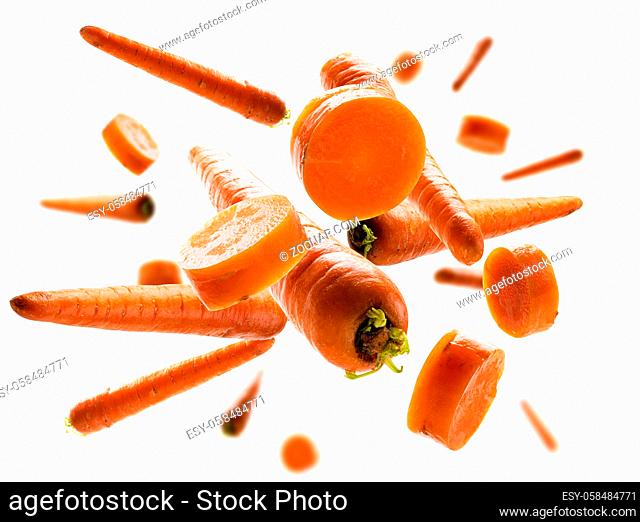 Ripe carrots whole and sliced levitate on a white background
