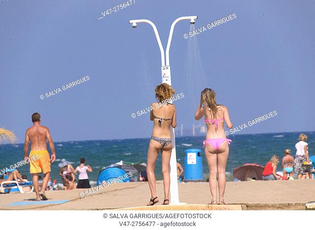 Two girls take a shower on the beach of Malvarrosa, Valencia, Spain, Europe
