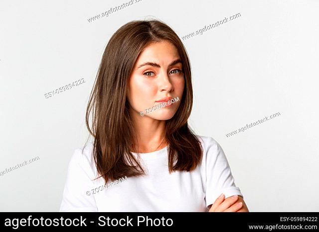 Close-up of attractive brunette girl looking skeptical and unamused