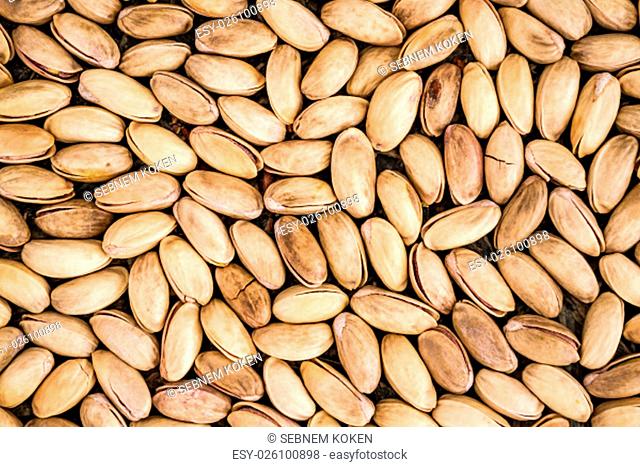 Pistachio nuts as texture or background on blue wooden background