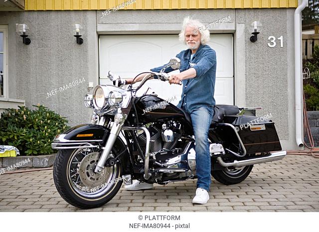 Portrait of senior man on vintage motorbike