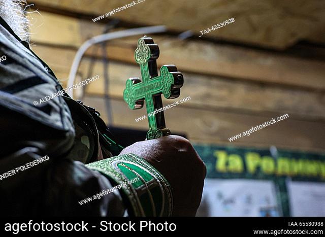 RUSSIA, ZAPOROZHYE REGION - NOVEMBER 27, 2023: Chaplain Father Oleg holds a cross during a prayer service. Alexander Polegenko/TASS