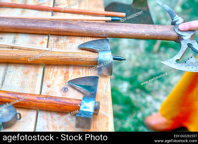 Viking battle ax set, large and small set of cold arms close-up on the background of a wooden table