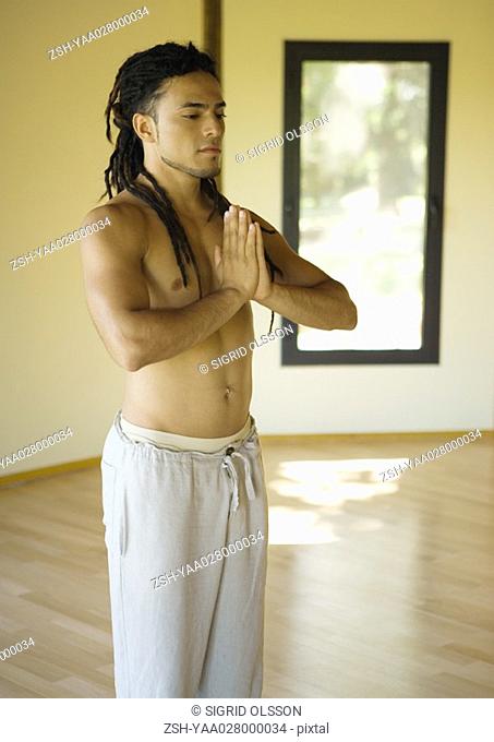 Yoga class, man standing in prayer position
