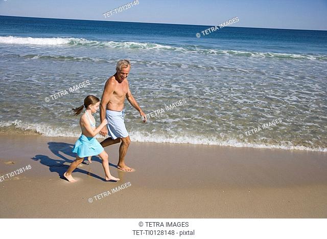 Father and daughter walking on beach