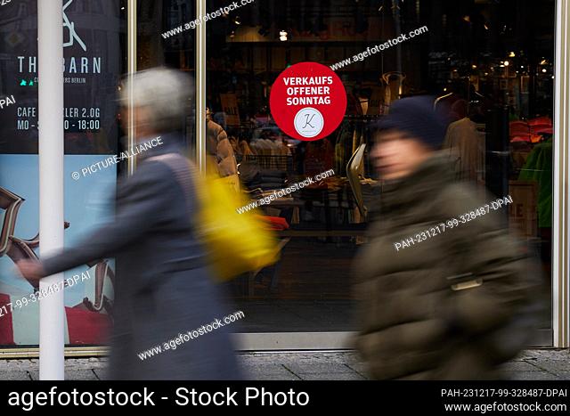 17 December 2023, Berlin: A sign on the door of a fashion store on Kurfürstendamm indicates that it is open for business on Sundays