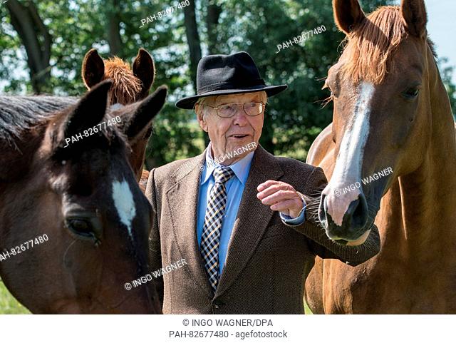 Henry C. Boehack, long-time president of the Duhner Wattrennen ('Duhnen mudflat race'), posing with his horses on his forse farm in Cuxhaven, Germany
