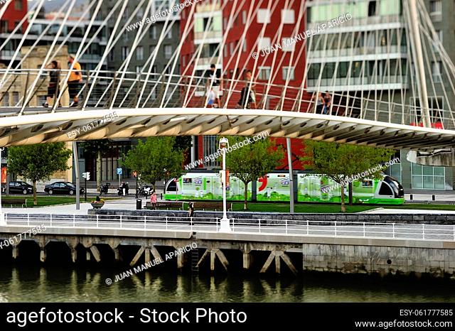 People cross Calatrava bridge with Tram at background, Bilbao, Basque Country, Biscay, Spain