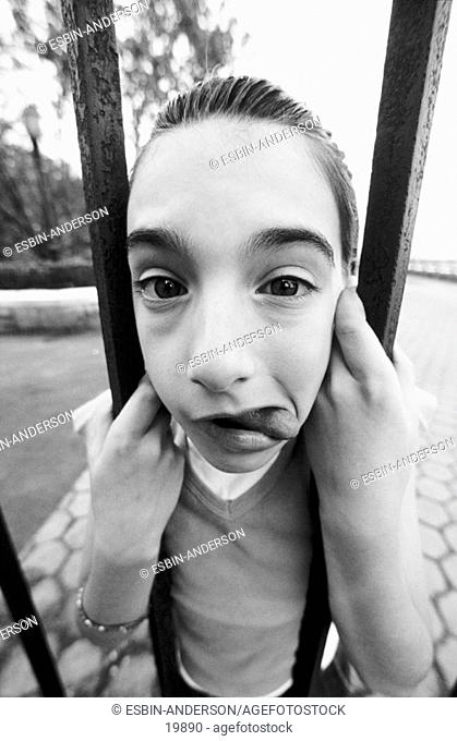Young girl's face caught in bars