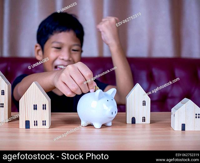 Boy saving money in a white pig piggy bank.Saving concept. Saving for the future