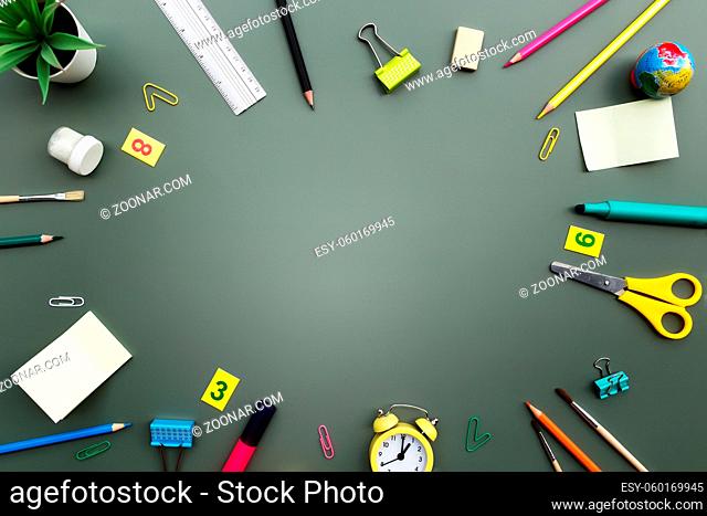 Back to school conceptual flat lay with different office supply objects and copy space area for text. Concept for primary and secondary school pupil on green...