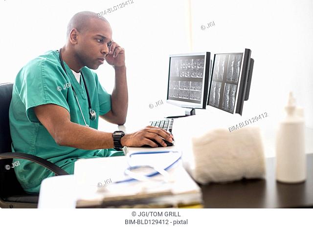 Black doctor working on computer in office