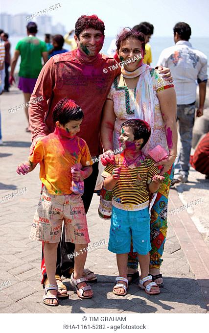 Indian family celebrating annual Hindu Holi festival of colours with powder paints at Nariman Point in Mumbai, formerly Bombay, India