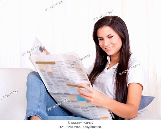 Woman sitting reading a newspaper