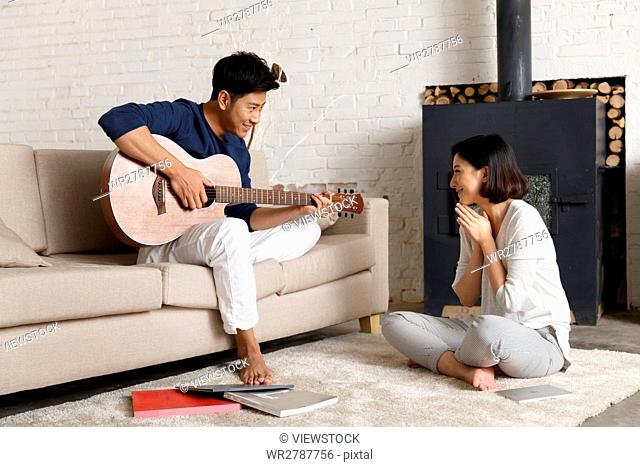 Young couple at home with guitar