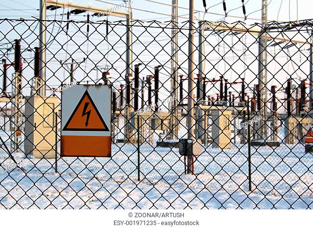 winter scene with warning signs on high voltage substation
