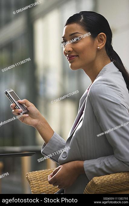 Pilipino businesswoman text messaging on cell phone
