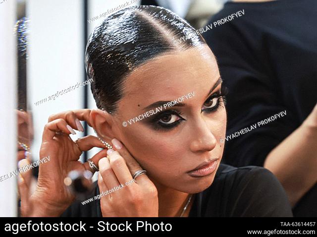 RUSSIA, MOSCOW - OCTOBER 21, 2023: A dancer puts on earrings backstage before the ""Kremlin Cup - Pride of Russia!"" dancing tournament at the State Kremlin...