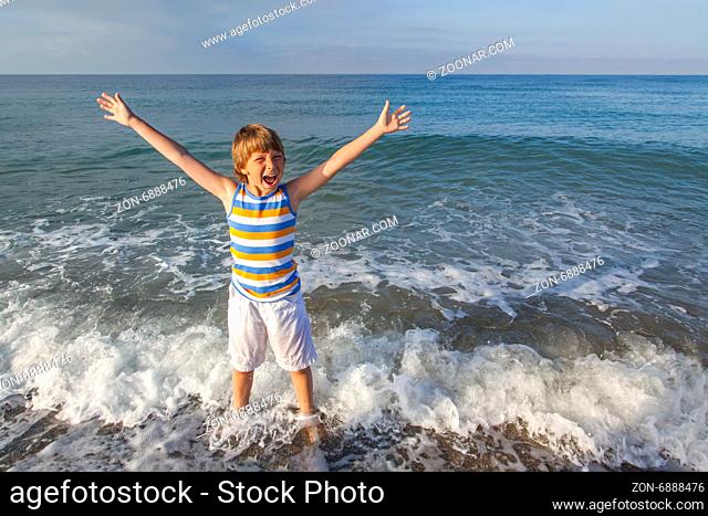 boy running through the water at the beach