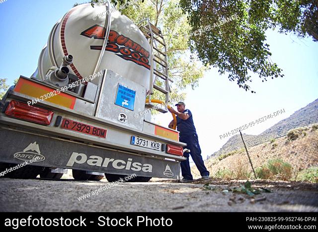 24 August 2023, Spain, Casabermeja: Diego, a driver for the water transport and supply company Aquatrans, prepares the tank of his truck to unload 25