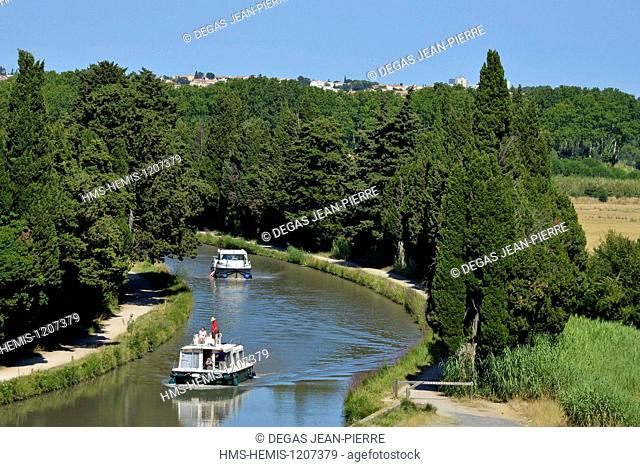 France, Herault, Beziers, Canal du Midi listed as World Heritage by UNESCO, pleasure boats downstream to the locks of Fonseranes in the middle of cypress