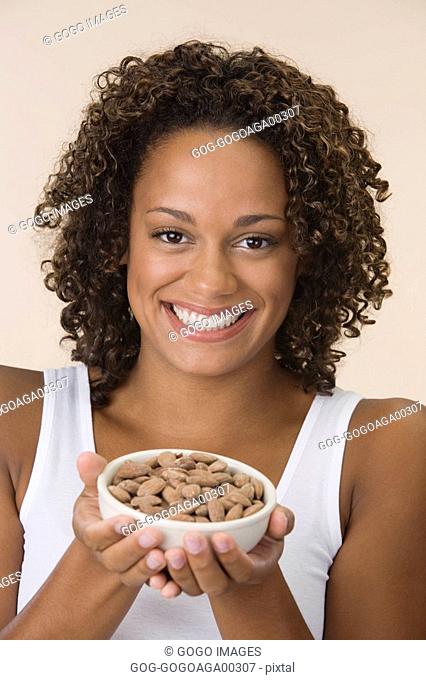 African woman holding bowl of almonds