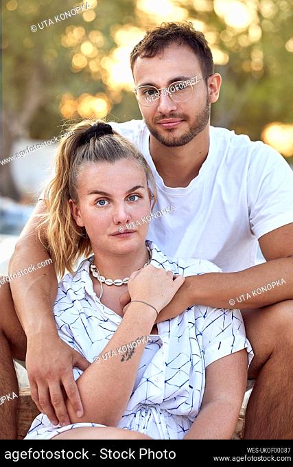 Young couple in casuals spending leisure time together in backyard during weekend