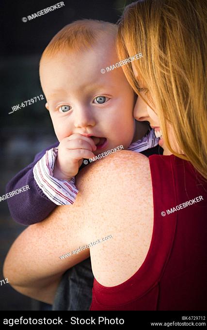 Adorable red head infant boy portrait with his mother outdoors in dramatic lighting