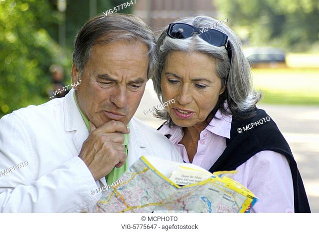 Ein aelteres grauhaariges Paar schaut in den Stadtplan, Hamburg| Old couple with grey hair look in a map - Hamburg, Germany, 30/06/2008